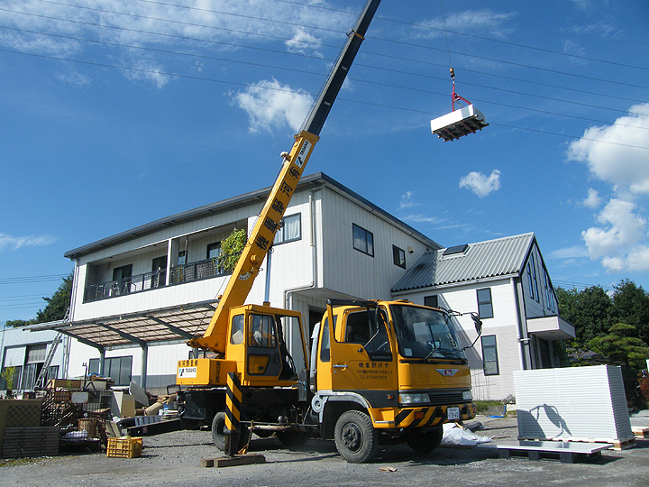 重機で機材を屋根へ上げる